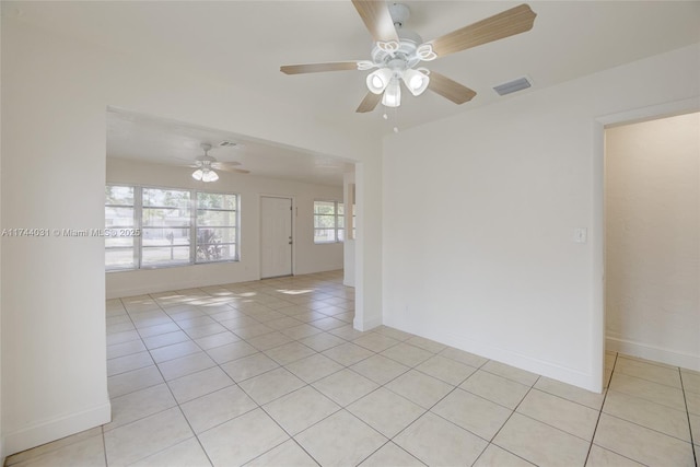 tiled spare room with ceiling fan