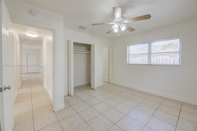 unfurnished bedroom with light tile patterned floors, a closet, and ceiling fan