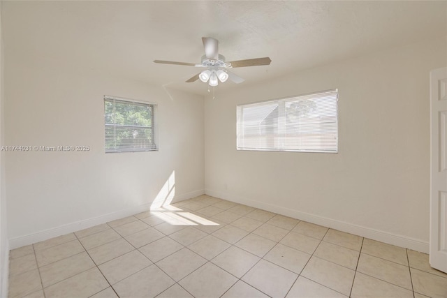 tiled spare room featuring ceiling fan