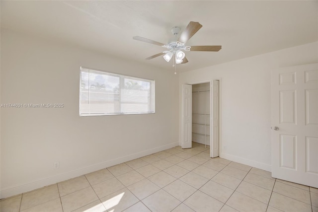 unfurnished bedroom featuring ceiling fan, a closet, and light tile patterned floors