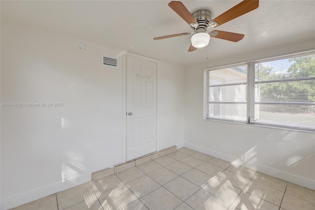 tiled empty room with ceiling fan