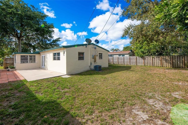 rear view of property featuring a lawn, a patio, and central air condition unit