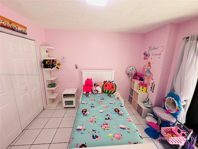 rec room with light tile patterned floors and a textured ceiling