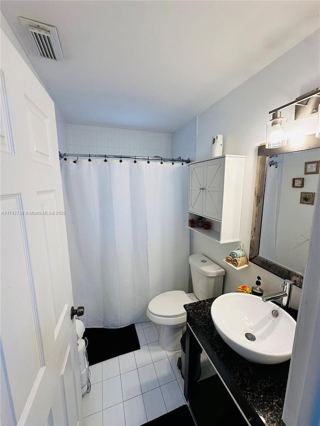 bathroom with vanity, a shower with curtain, toilet, and tile patterned floors