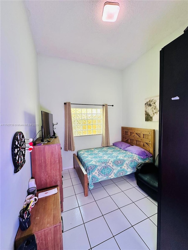 tiled bedroom featuring a textured ceiling