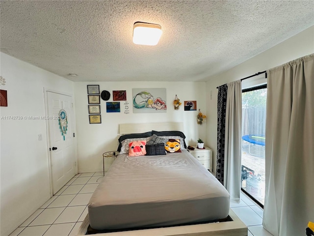 tiled bedroom with a textured ceiling and access to exterior