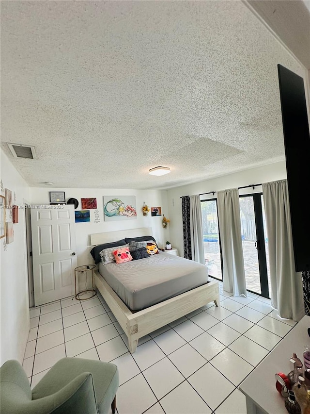 bedroom with a textured ceiling, access to outside, and light tile patterned floors