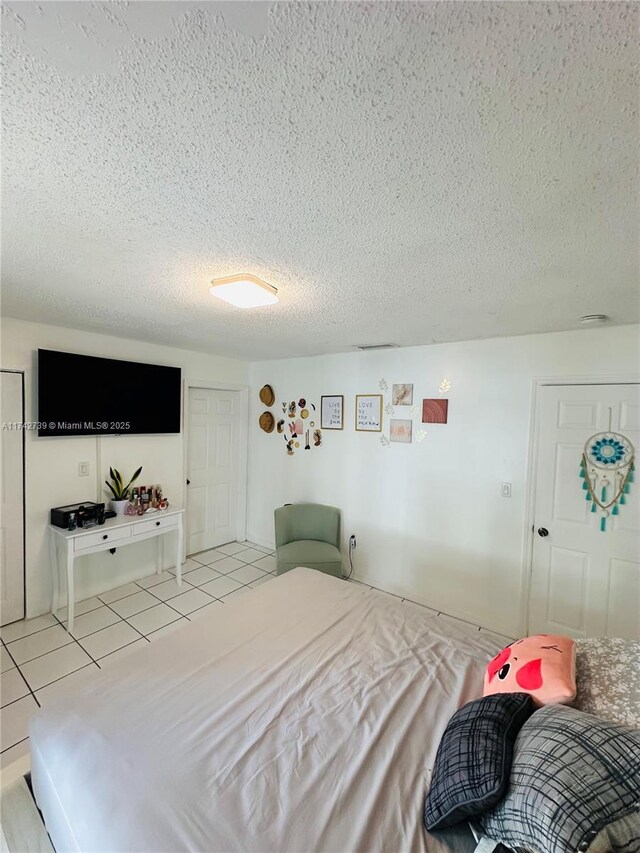 bedroom featuring a textured ceiling and light tile patterned flooring