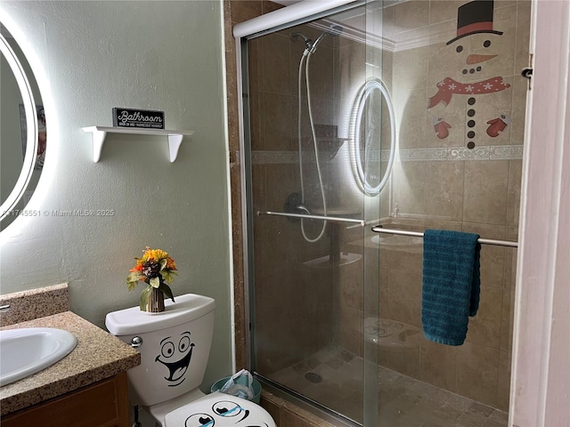 bathroom with vanity, toilet, and a shower with shower door