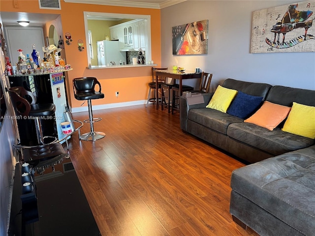 living room with hardwood / wood-style flooring and crown molding