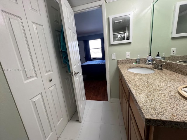 bathroom with ornamental molding, vanity, and tile patterned flooring