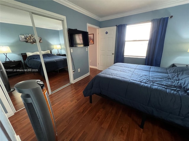 bedroom featuring dark wood-type flooring, crown molding, and a closet