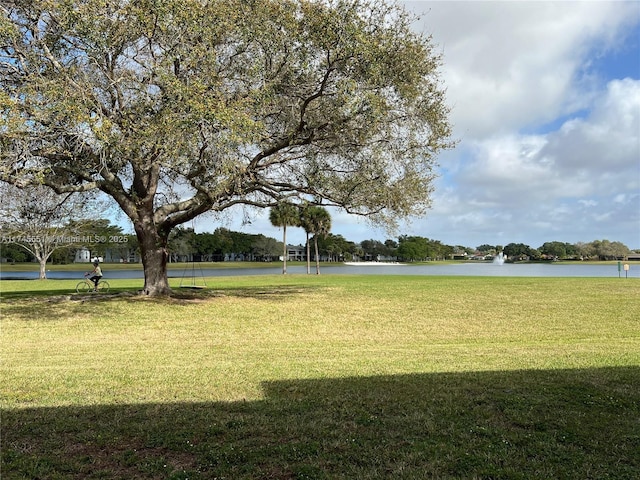 view of home's community featuring a water view and a yard