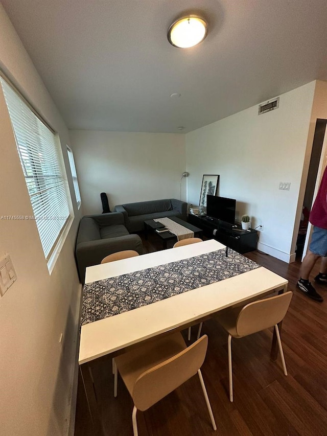 interior space featuring baseboards, visible vents, and wood finished floors