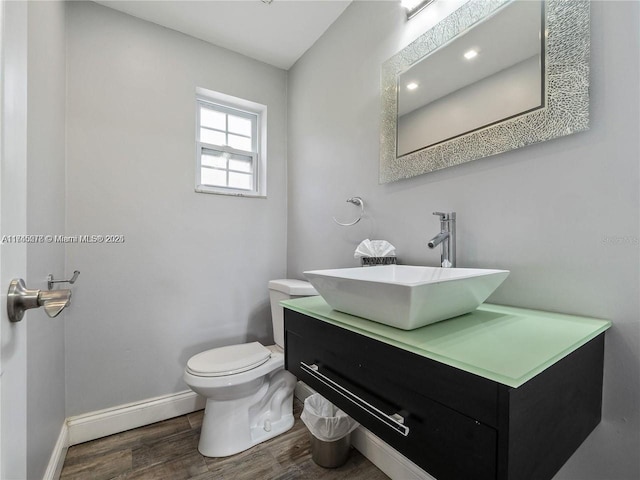 bathroom with baseboard heating, vanity, toilet, and hardwood / wood-style floors