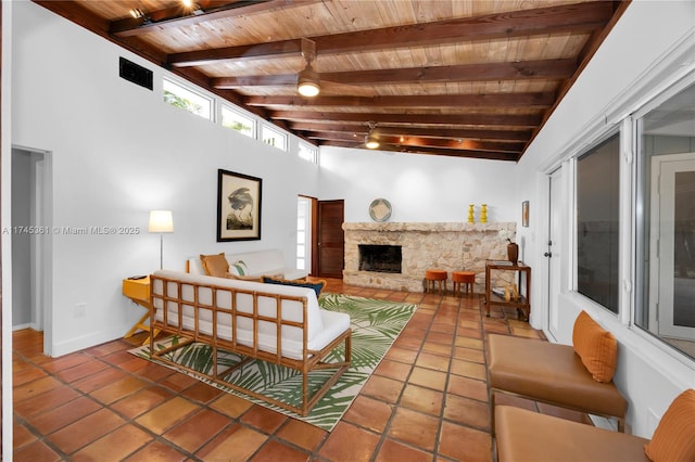 living room with beamed ceiling, a stone fireplace, and wooden ceiling