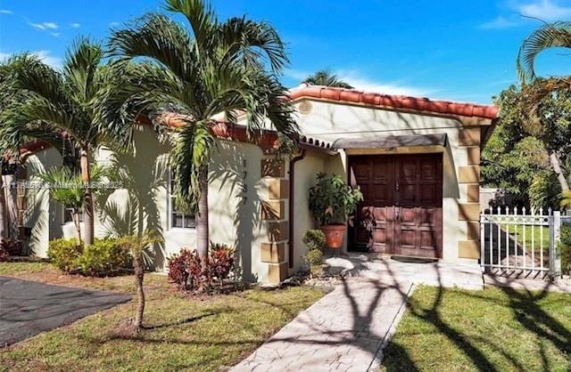 1787 NE 174th St, North Miami Beach, FL 33162 - view of front of house with fence and stucco siding