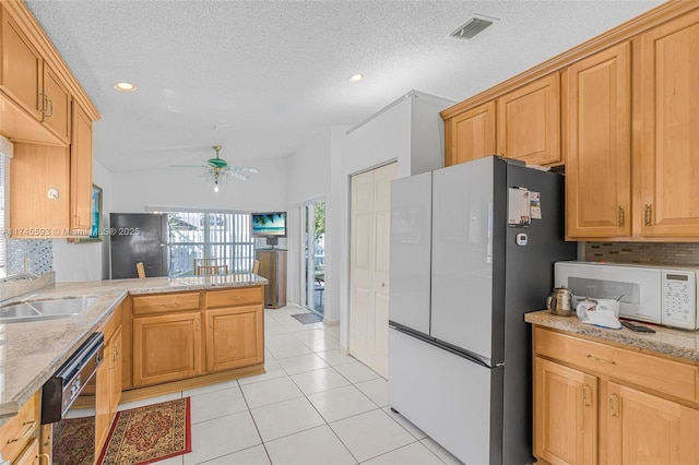 kitchen with light tile patterned floors, refrigerator, black dishwasher, tasteful backsplash, and kitchen peninsula