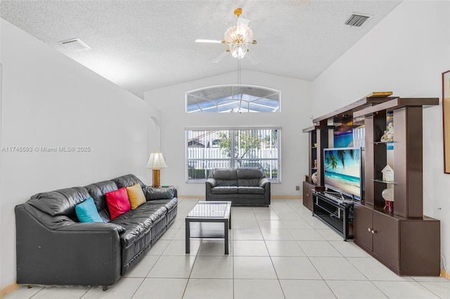 living room with light tile patterned flooring, lofted ceiling, and a textured ceiling