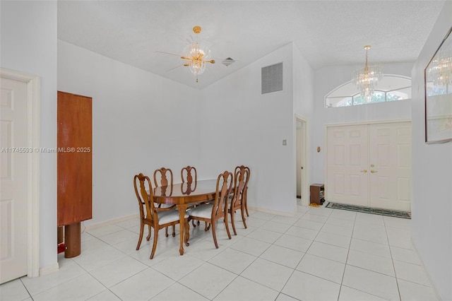 dining space featuring high vaulted ceiling, light tile patterned floors, a textured ceiling, and a notable chandelier