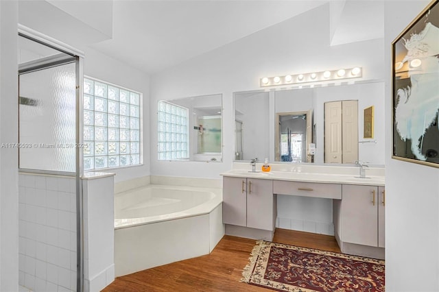 bathroom featuring lofted ceiling, vanity, hardwood / wood-style flooring, and separate shower and tub