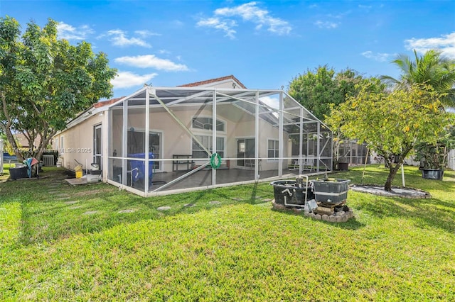 rear view of property with a lanai and a lawn