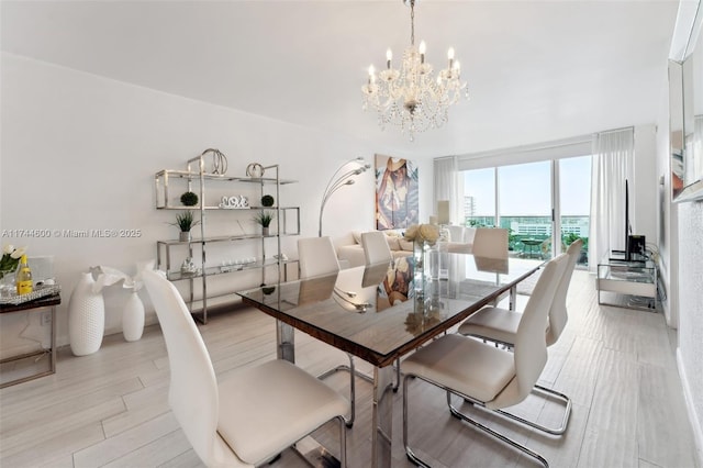 dining space featuring a wall of windows, light hardwood / wood-style floors, and a chandelier