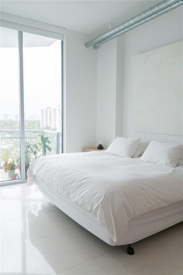 bedroom featuring expansive windows, a view of city, and tile patterned flooring