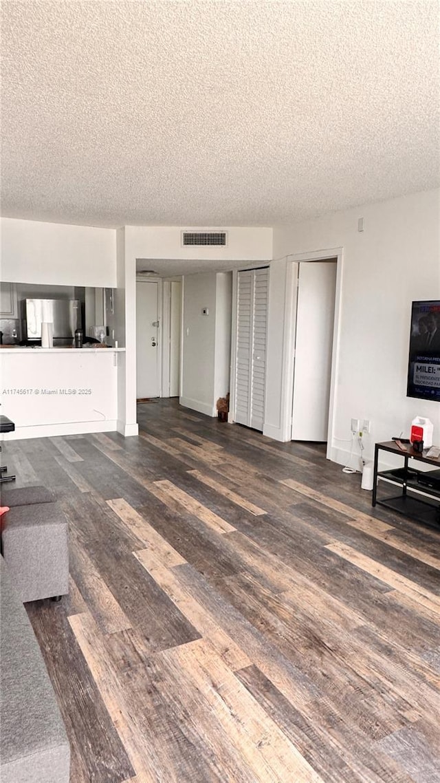 living room featuring dark hardwood / wood-style floors and a textured ceiling