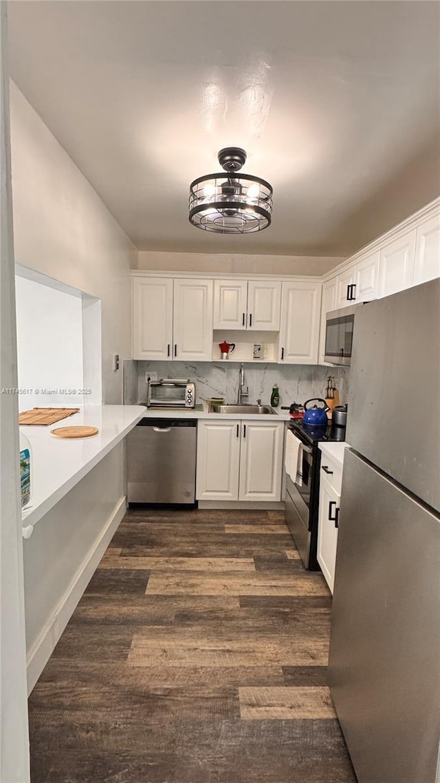 kitchen with dark hardwood / wood-style floors, sink, white cabinets, decorative backsplash, and stainless steel appliances