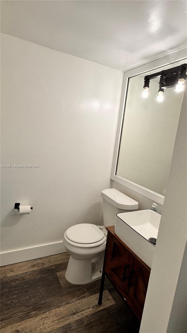 bathroom featuring vanity, wood-type flooring, and toilet