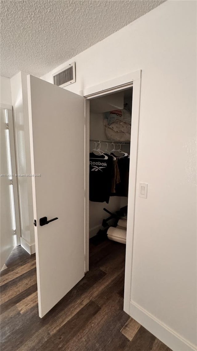 corridor featuring dark hardwood / wood-style floors and a textured ceiling