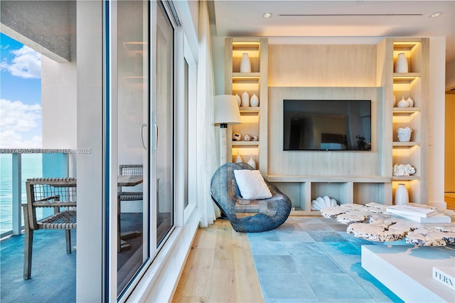 interior space featuring a water view, light hardwood / wood-style flooring, and built in shelves