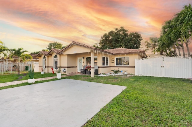 back of property featuring fence, a yard, stucco siding, and a gate