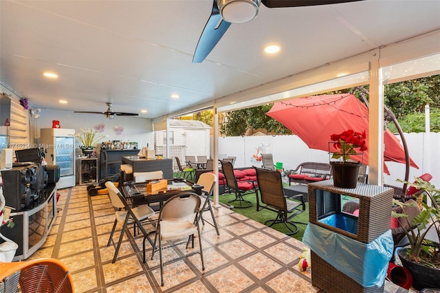 view of patio / terrace with a fenced backyard, an outdoor structure, outdoor dining area, and a storage unit