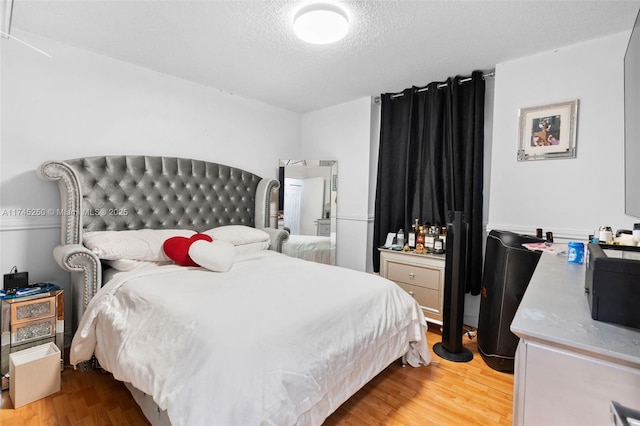 bedroom featuring a textured ceiling and wood finished floors
