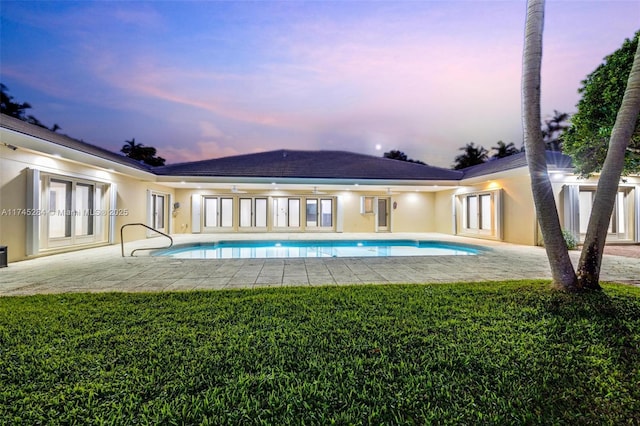 pool with a patio, french doors, and a lawn