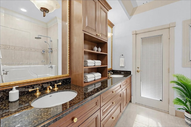 bathroom with a shower, tile patterned flooring, and vanity