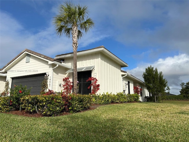 view of side of home with a garage and a yard