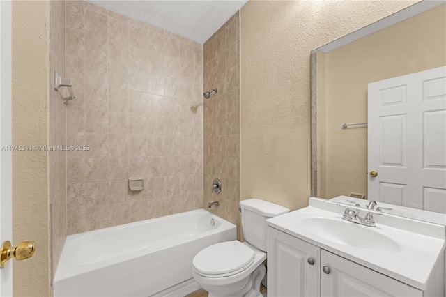 full bathroom featuring tiled shower / bath, vanity, and toilet