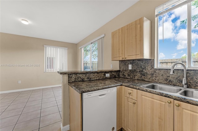 kitchen with light tile patterned flooring, light brown cabinetry, sink, white dishwasher, and kitchen peninsula