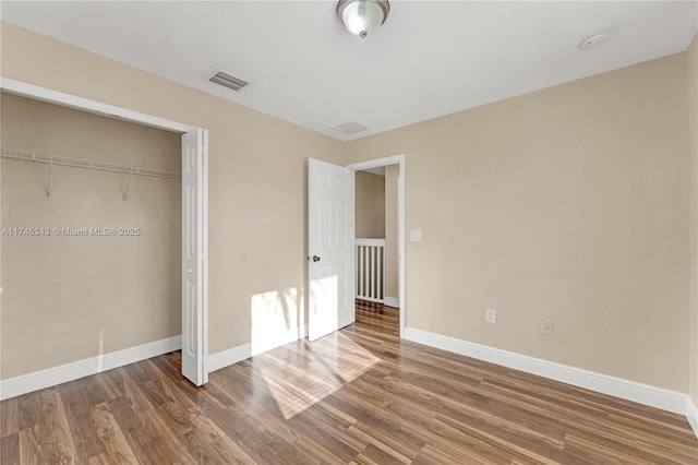 unfurnished bedroom with dark hardwood / wood-style floors and a closet