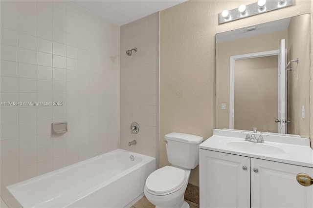 full bathroom featuring tiled shower / bath combo, vanity, and toilet