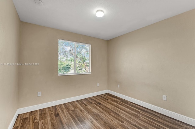 unfurnished room with dark hardwood / wood-style flooring