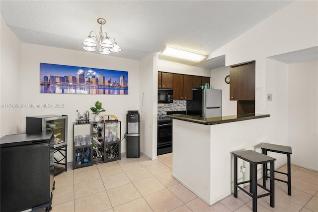 2866 S University Dr Unit 5307, Davie, FL 33328 - kitchen featuring a kitchen breakfast bar, dark brown cabinetry, dark countertops, light tile patterned floors, and black appliances