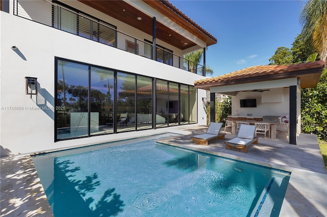 back of property with a patio, ceiling fan, and exterior kitchen