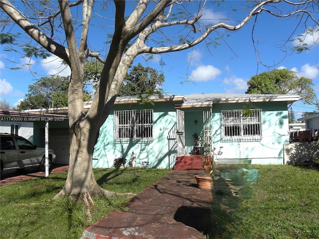 view of front of home with a front yard and a carport