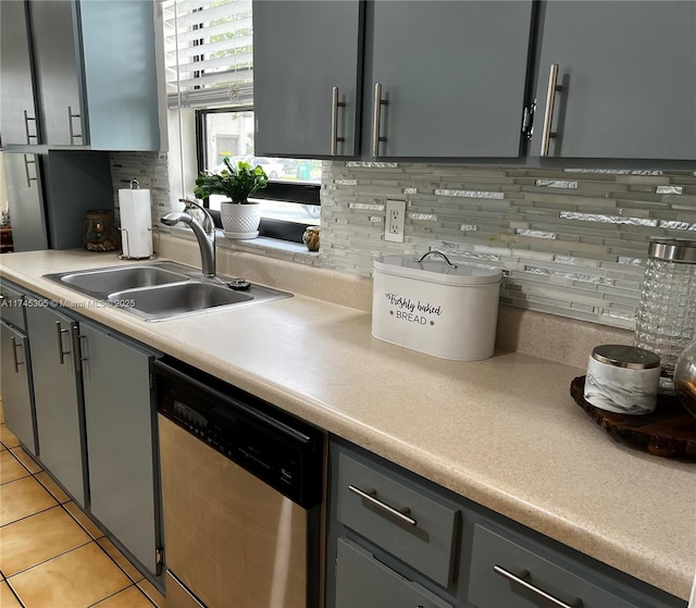 kitchen with gray cabinets, light countertops, light tile patterned flooring, a sink, and dishwasher