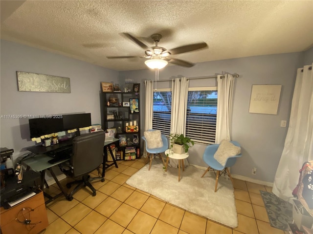 office space featuring light tile patterned floors, a textured ceiling, a ceiling fan, and baseboards