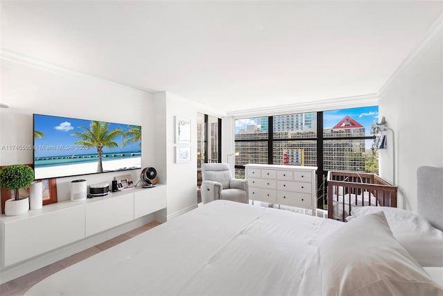 bedroom with light wood-style flooring, ornamental molding, and a city view